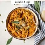 Pumpkin pasta in a bowl with a fork and fresh sage.
