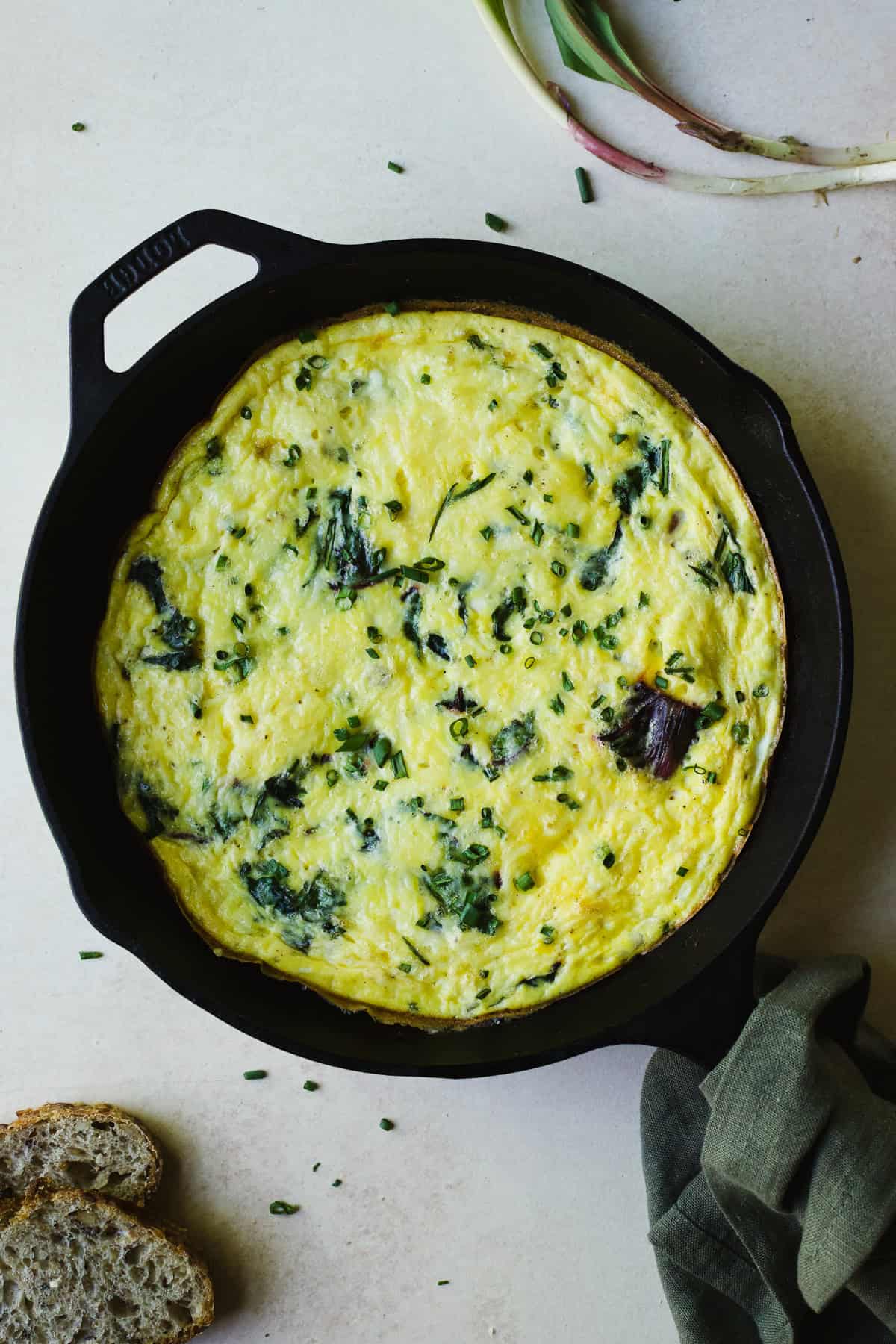 Swiss chard frittata with cottage cheese in a cast iron skillet.