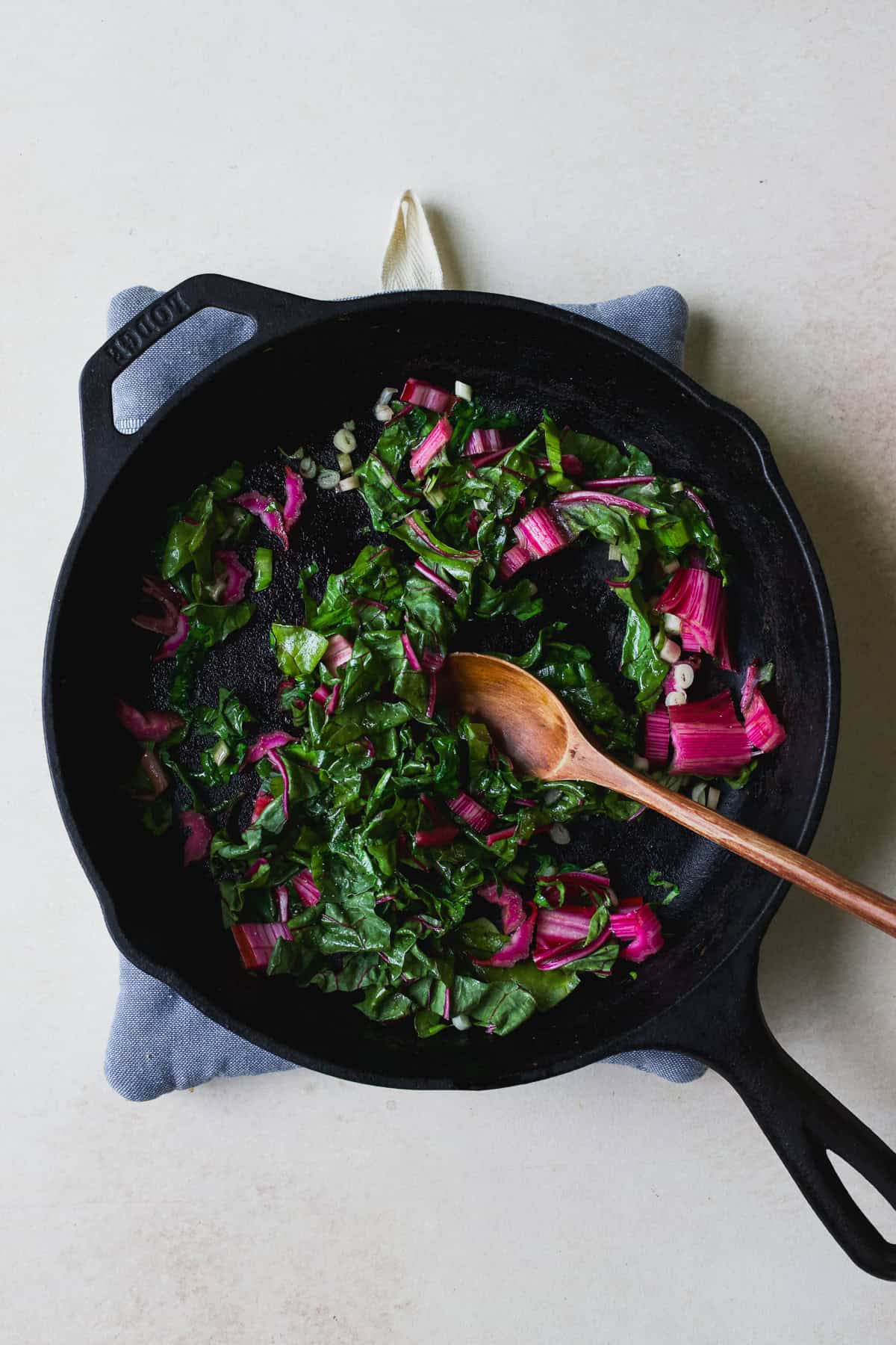Sautéeing Swiss chard and ramps in a cast iron skillet.
