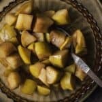 Cinnamon-spiked stewed apples in a bowl with a spoon.